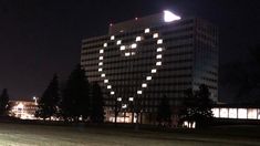 a large building lit up at night with trees in the foreground