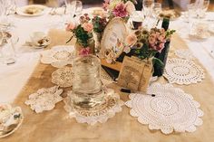 the table is set with doily and place settings for guests to sit down at