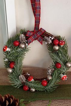 a christmas wreath with pine cones and ornaments