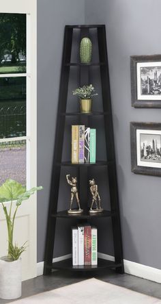 a corner shelf with books and vases on it in front of a gray wall