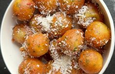 a white bowl filled with fried food covered in parmesan sprinkles