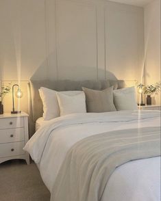 a bed with white sheets and pillows in a bedroom