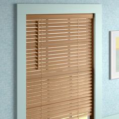 an open window with wooden blinds in a blue room