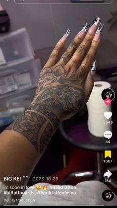 a woman's hand with tattoos on it