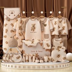 the baby's clothes are on display in front of brown drapes