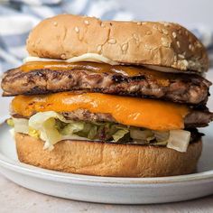 a hamburger with cheese and lettuce on a plate