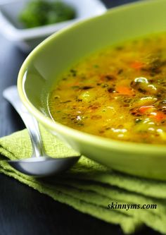 a green bowl filled with soup on top of a table