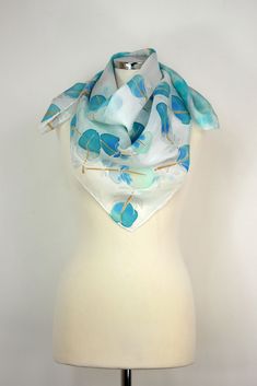 Size: approx. 86 x 86 cm. One-of-a-kind hand-painted silk scarf featuring a whimsical yet subtle design of simple feathers. Large square hand-painted silk scarf hand-dyed and hand-painted in neutral shades of turquoise blue and vibrant navy blue painted on each feather made of luxury habotai silk fabric. This is a classic silk square scarf. First, I hand-dyed the background and then paint the ends to achieve a dramatic and intricate look. I chose my trademark feathers of Heron and used feminine, Elegant Hand Painted Blue Silk Scarf, Artsy Blue Scarf As A Gift, Artsy Blue Scarf As Gift, Artsy Blue Scarf Perfect As A Gift, Artsy Blue Scarf For Gift, Artsy Blue Scarves As Gifts, Hand Painted Blue Silk Scarf For Gift, Artsy Blue Silk Scarf As Gift, Artsy Blue Silk Scarf Gift