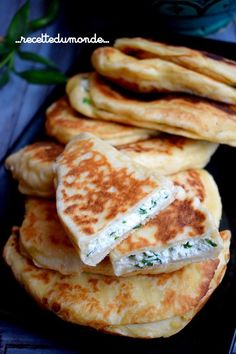 there are several pancakes stacked on top of each other with cheese and spinach in the middle