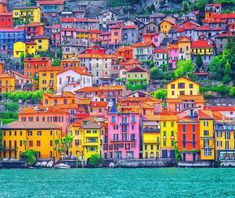 the colorful houses are on the hillside above the water