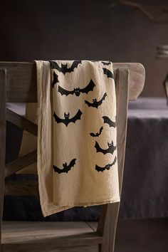 a table with a black and white bat design on it next to a wooden chair