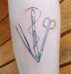 a tattoo with scissors and needles on it