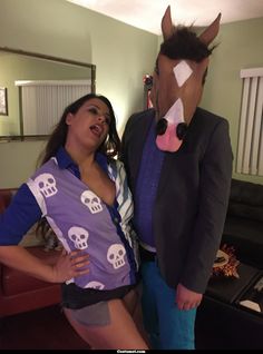 a woman standing next to a man wearing a horse mask