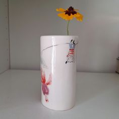 a flower in a white vase on a table