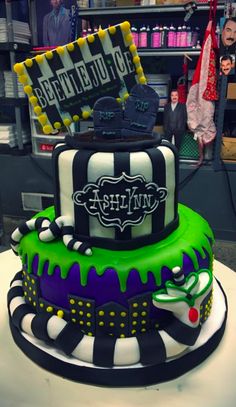 a three tiered cake decorated with black, white and green icing