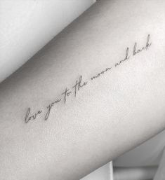 a woman's arm with the words, i love you to the moon and back written in cursive font