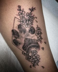 a dog paw and flowers tattoo on the right arm, with black ink in it