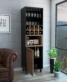 a living room filled with furniture and a tall cabinet next to a window that has wine bottles on it