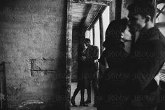 black and white photograph of people standing in an old building by jovo photography for stocksy