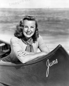 a black and white photo of a woman sitting in a boat with the name june written on it