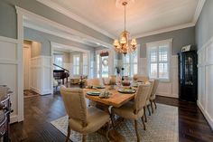 a dinning room table with chairs and a piano in the backround area