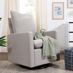 a chair with a blanket on top of it in front of a potted plant