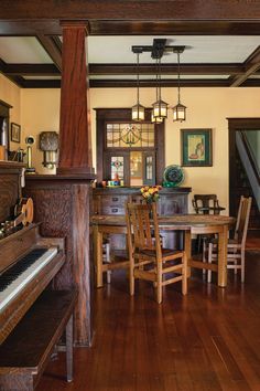 a room with a piano, table and chairs