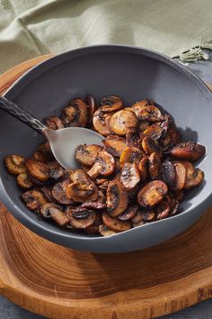 a pan filled with cooked mushrooms on top of a wooden cutting board