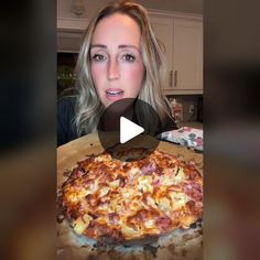 a woman holding a pizza in front of her face and making a heart shape on it