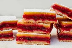 several desserts stacked on top of each other with powdered sugar and jelly filling