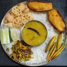 a plate with rice, pickles and other food items