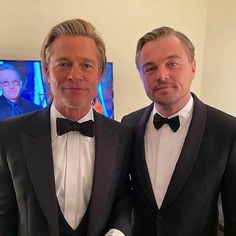 two men in tuxedos standing next to each other