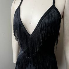 a mannequin wearing a black dress with fringes