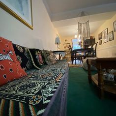 a living room filled with furniture and pictures on the wall