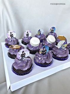 cupcakes with purple frosting and decorations on top