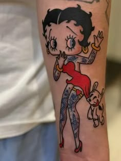 a person with a tattoo on their arm holding a dog and wearing a red dress