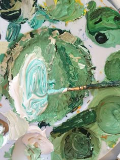 an artist's palette with green and white paint