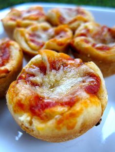 several mini pizzas on a white plate