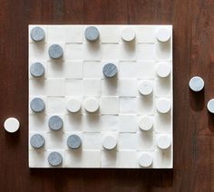 several white and gray circles on a wooden surface next to two smaller round dots that are arranged in the shape of squares