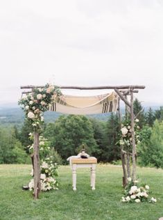 an outdoor ceremony setup with white flowers and greenery