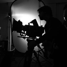 a man standing next to a camera in a dark room