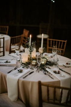 the table is set with silverware, candles and napkins for an elegant dinner