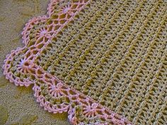 a crocheted rug with pink trim on it