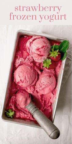 two scoops of strawberry ice cream in a metal pan with a green leaf on top