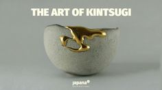 a white and gold ring sitting on top of a gray stone bowl with an animal in the middle