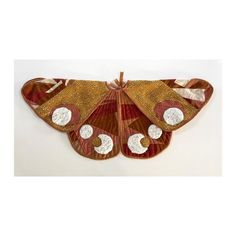 a large brown and white butterfly on a white surface with circles around it's wings