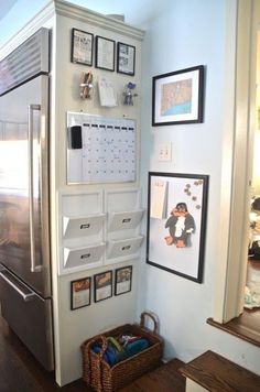 a white refrigerator freezer sitting inside of a kitchen next to pictures on the wall