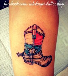 a tattoo on the leg of a woman with boots