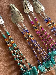 several different colored beads and silverware hanging on a wall