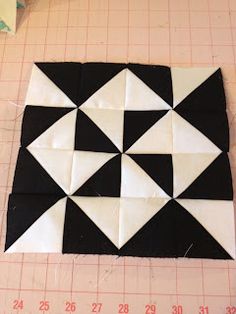 a black and white patchwork design on a piece of paper next to a ruler